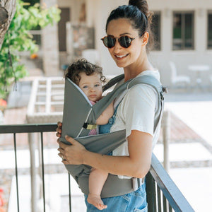 A mom with sun glasses wears the Cococho Ergonomic Baby Carrier in the front position